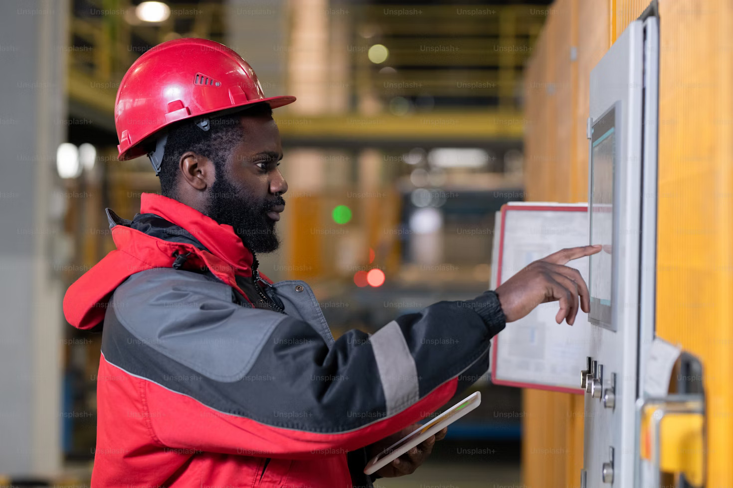 Three workers in safety vests and helmets standing in a warehouse