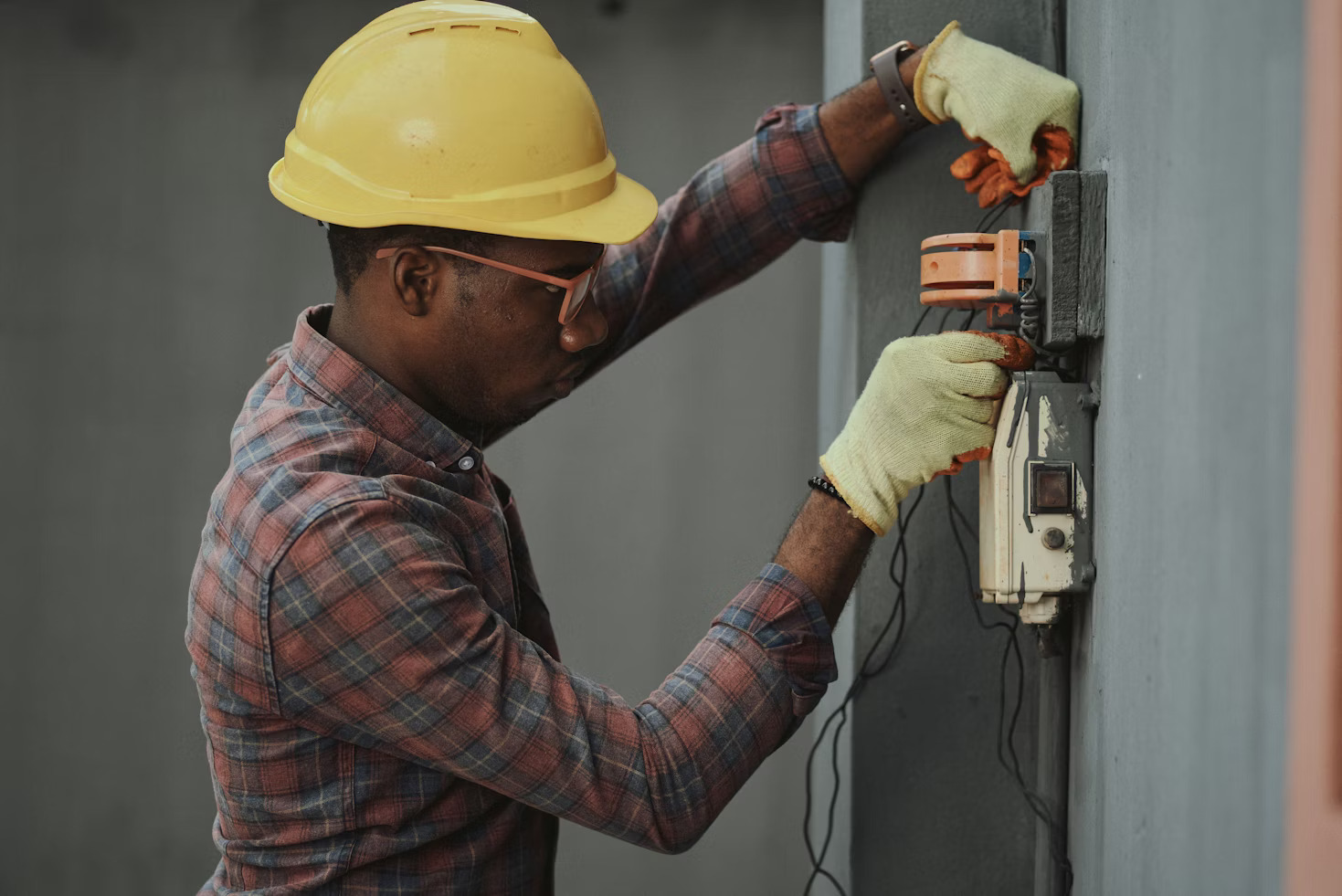 Worker in a white cap and blue uniform working on machinery in a factory