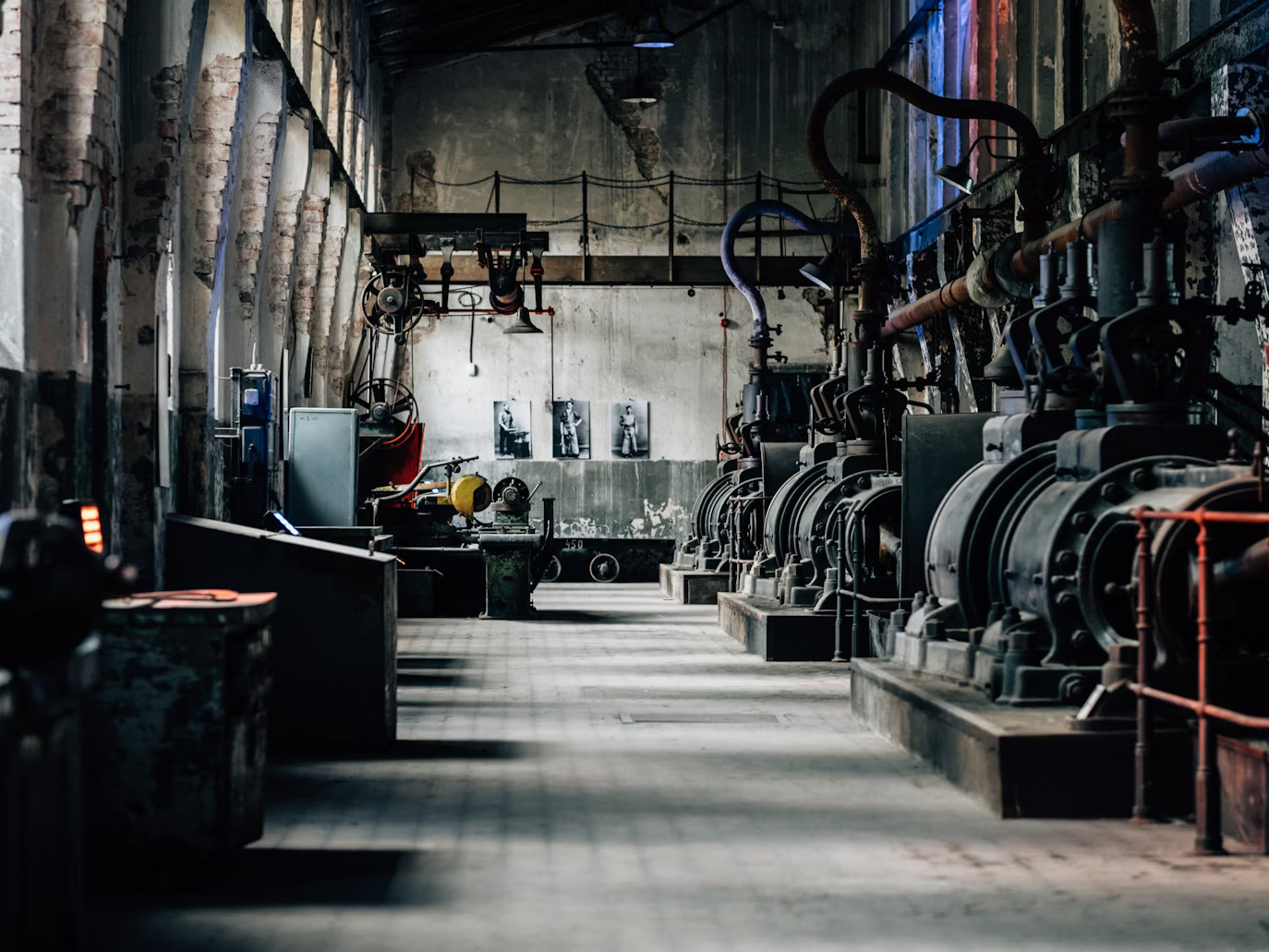 Worker in a white cap and blue uniform working on machinery in a factory