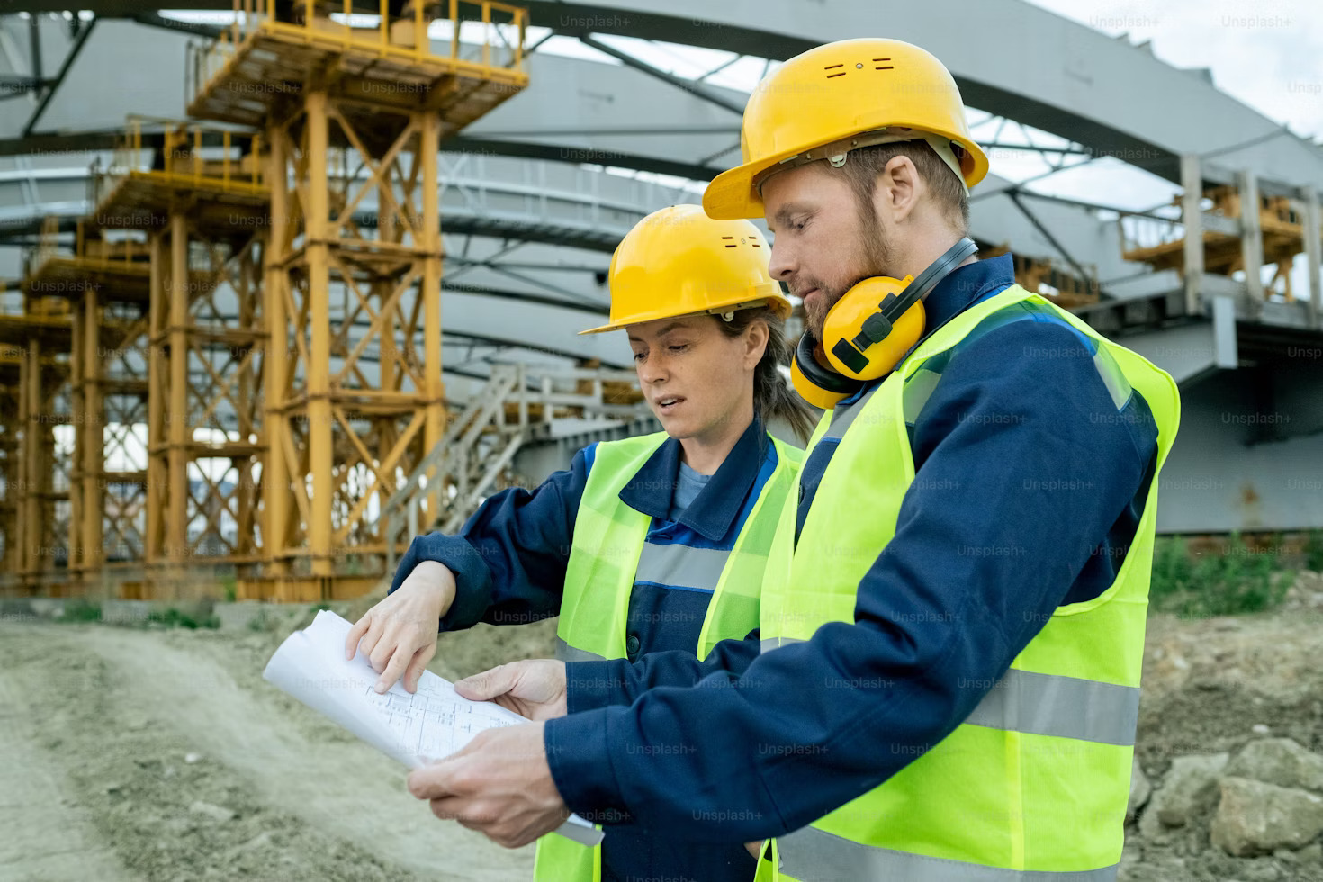 Worker in a white cap and blue uniform working on machinery in a factory